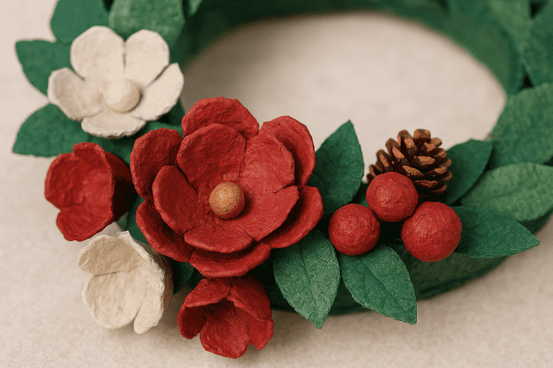 Detail květů a ozdob z obalů od vajíček na vánočním věnci